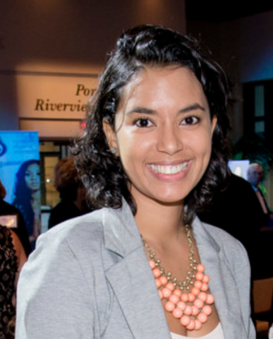 headshot of Isabelle Clerie. She has brown, medium length hair. She is wearing a grey shirt and a necklace. She is smiling.