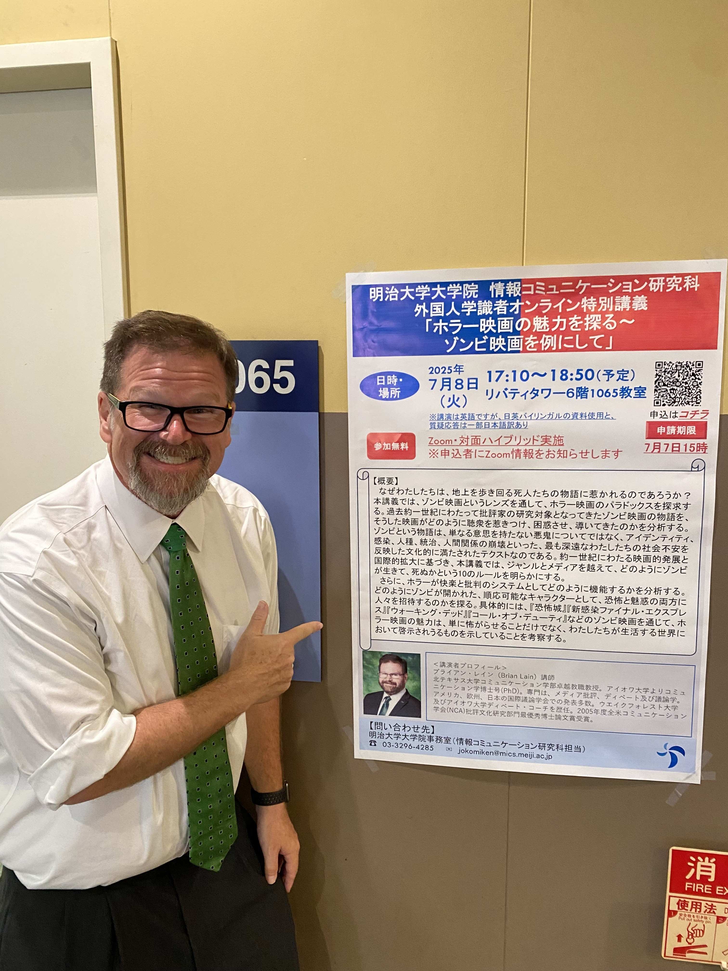 Dr. Brian Lain posing with poster advertising his lecture