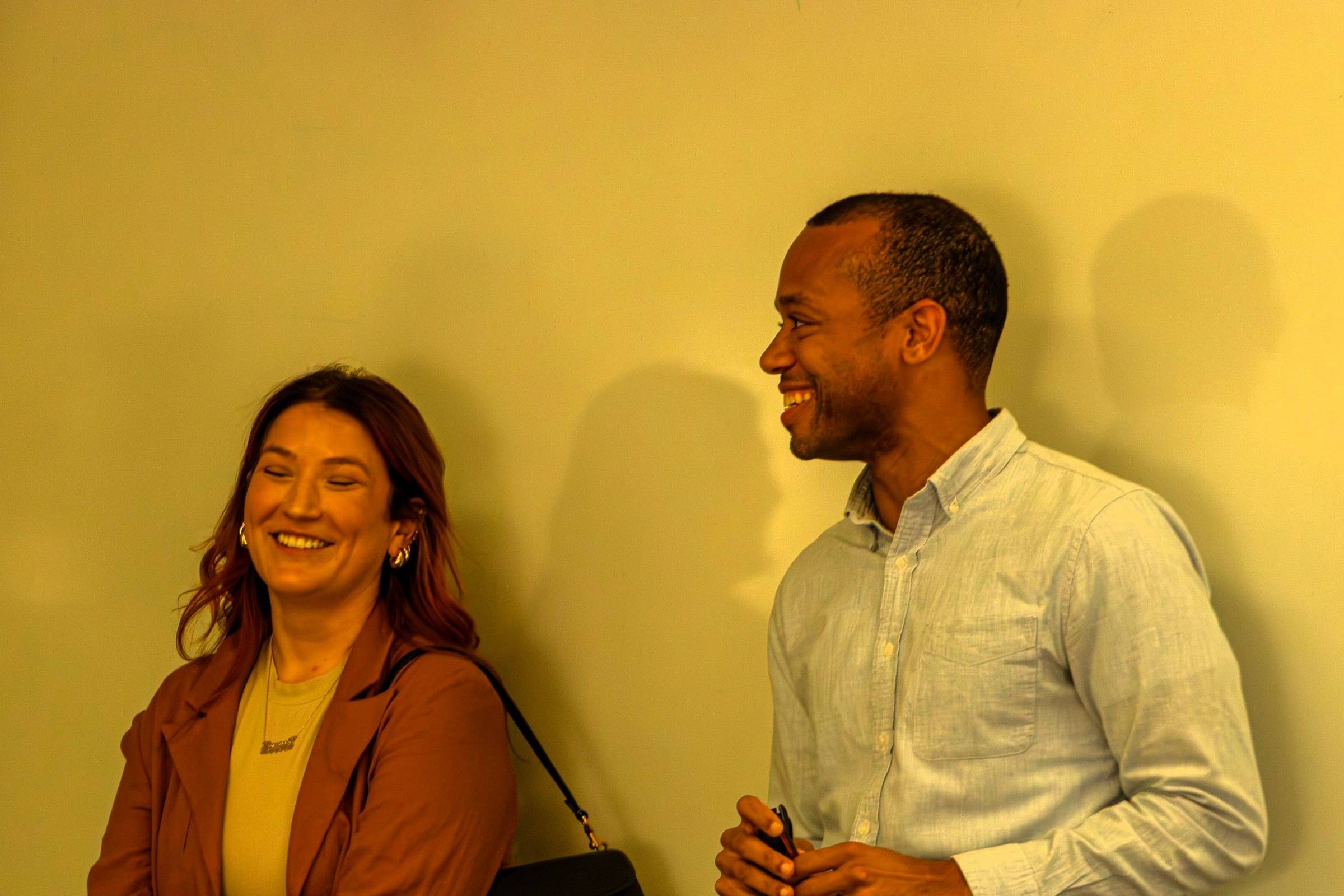 Alumni speakers smiling in front of white board during presentation