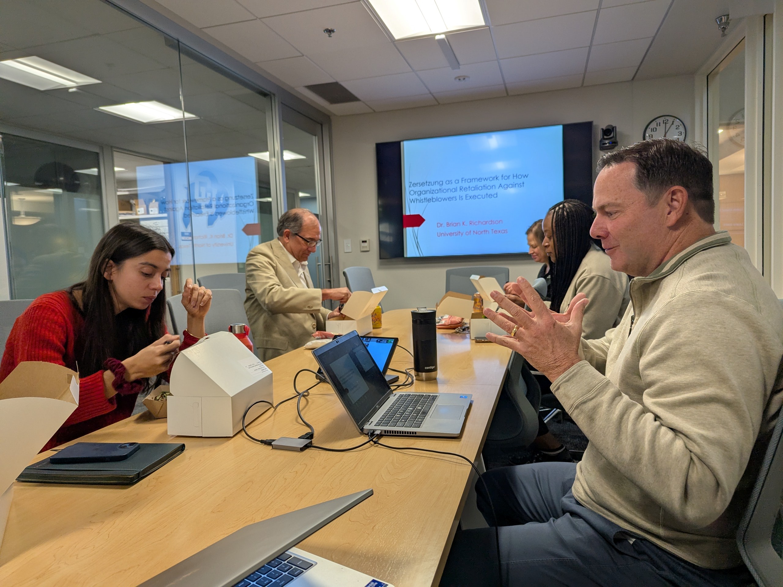 Dr. Brian Richardson presenting while sitting at a table