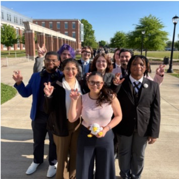 Debaters posing in group with eagle caw