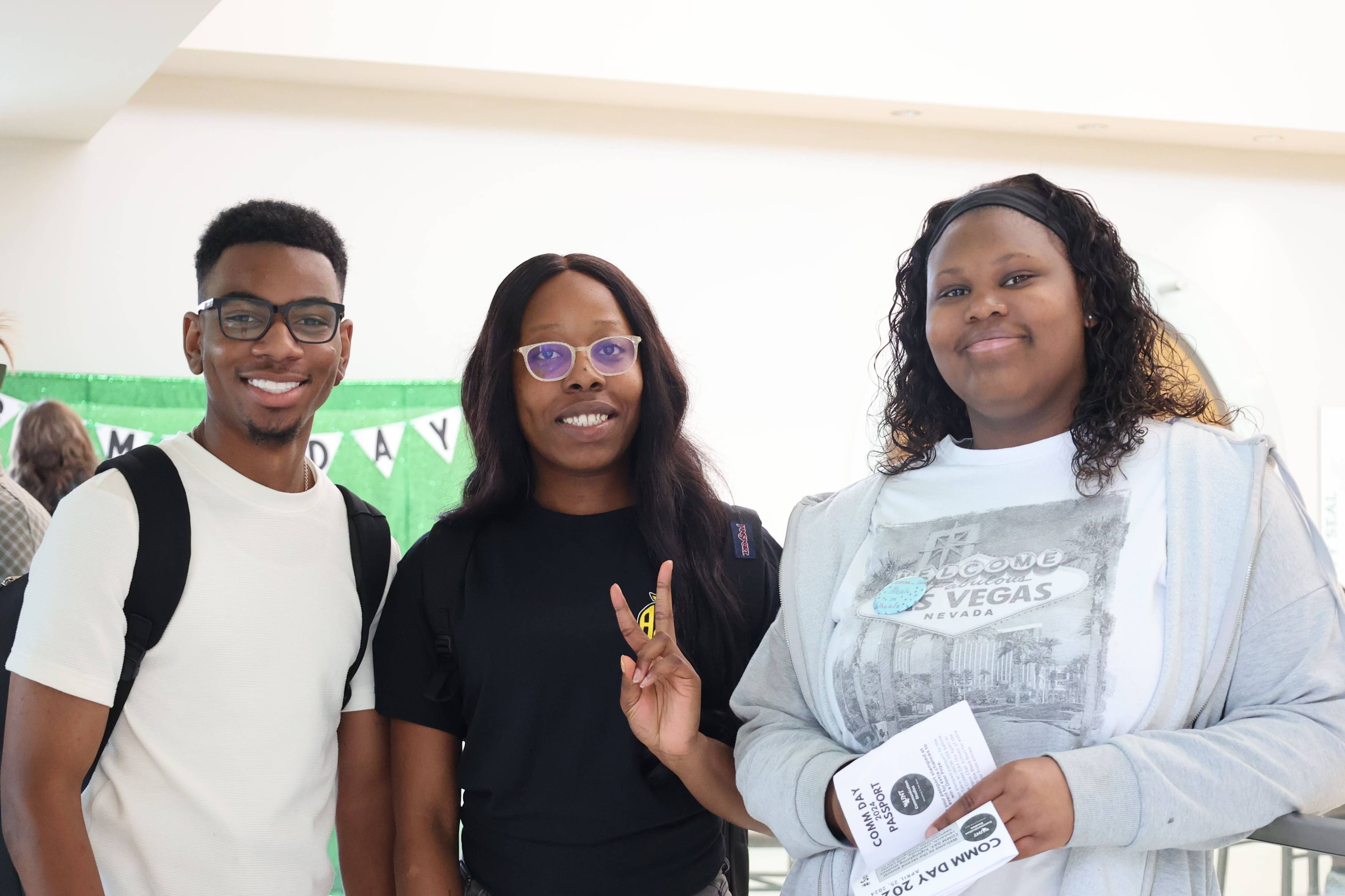 Three students smiling for picture on COMM Day