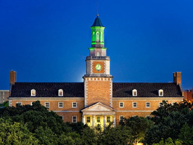 Picture of the tower of the University of North Texas admin building at night bathed in green light