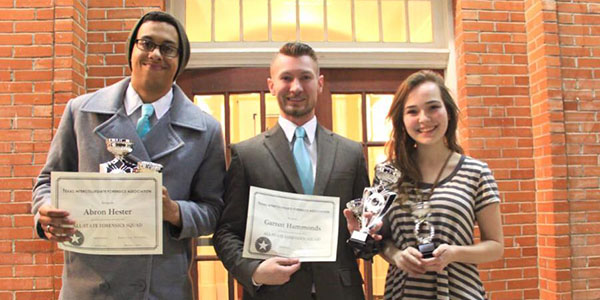 UNT Debaters hold trophies and certificates