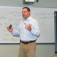 Dr. Brian Richardson giving a talk in front of a whiteboard