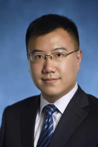 Hanchen Jiang, Ph.D. posing in front of blue background