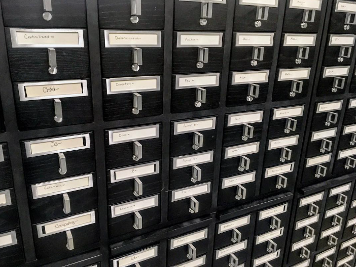 Black filing cabinet drawers labeled with various topics