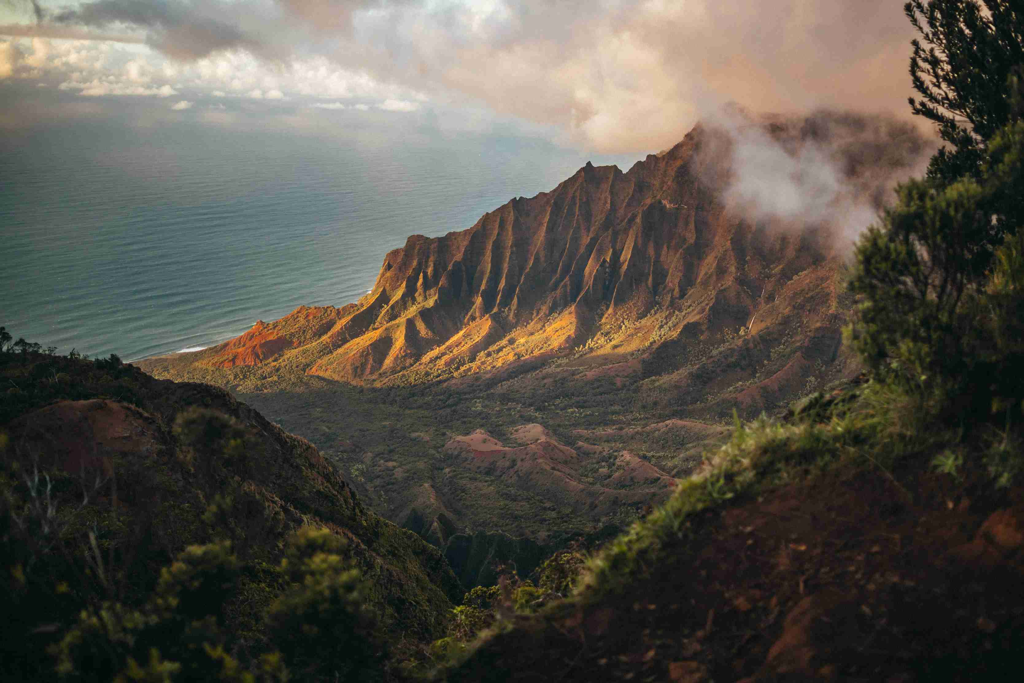 Aerial view of steep green mountains and ocean cliffs