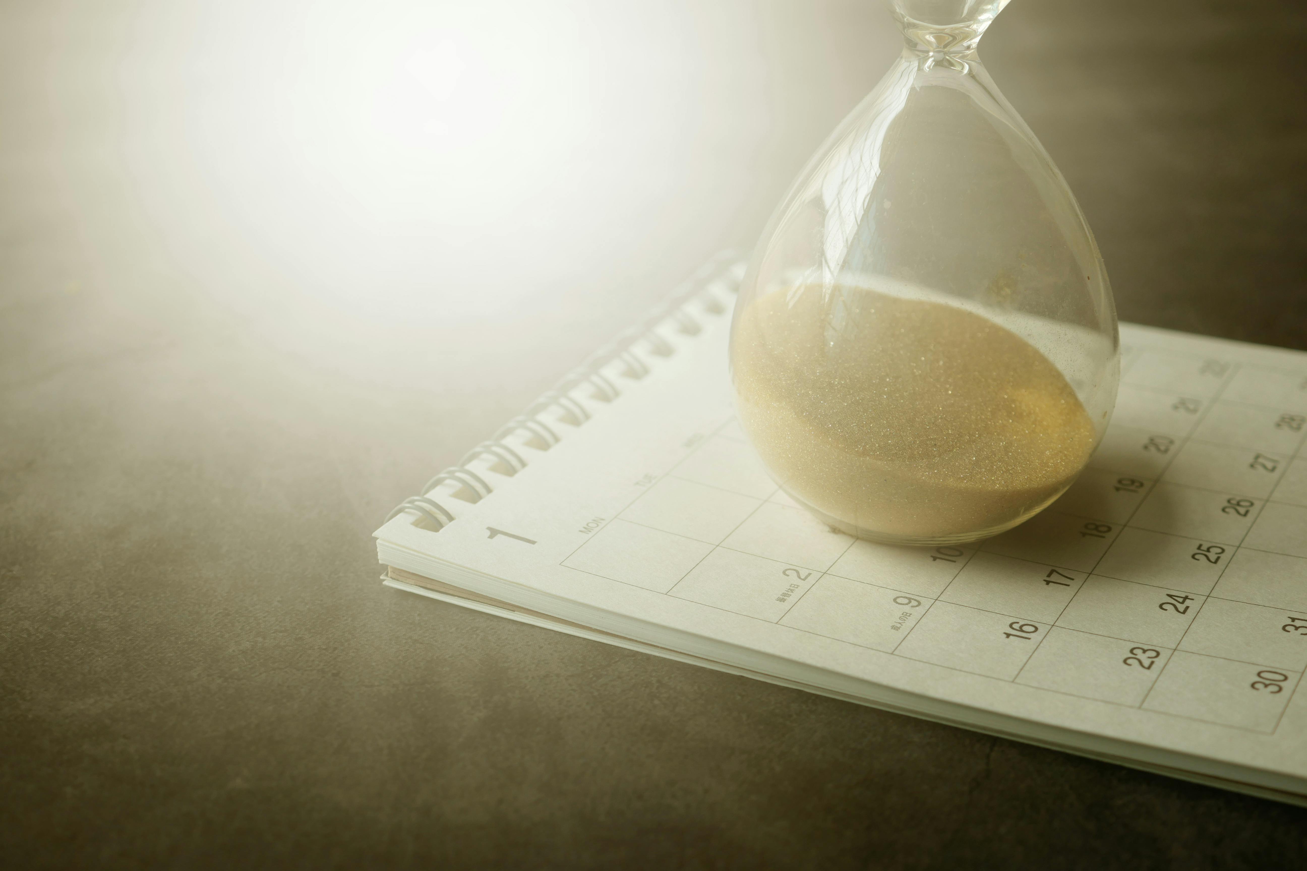 Hourglass on top of an open calendar
