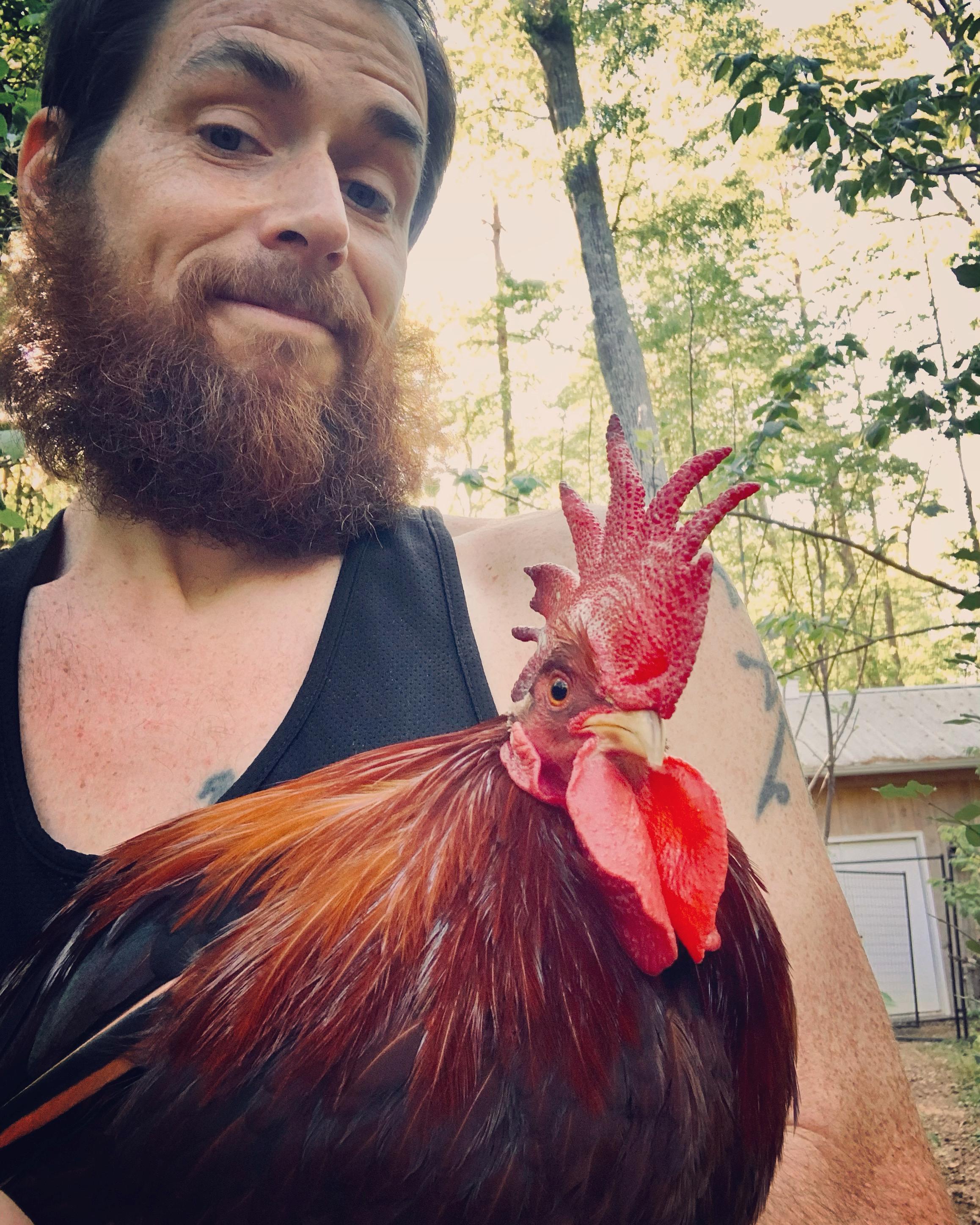 A person sits with a chicken