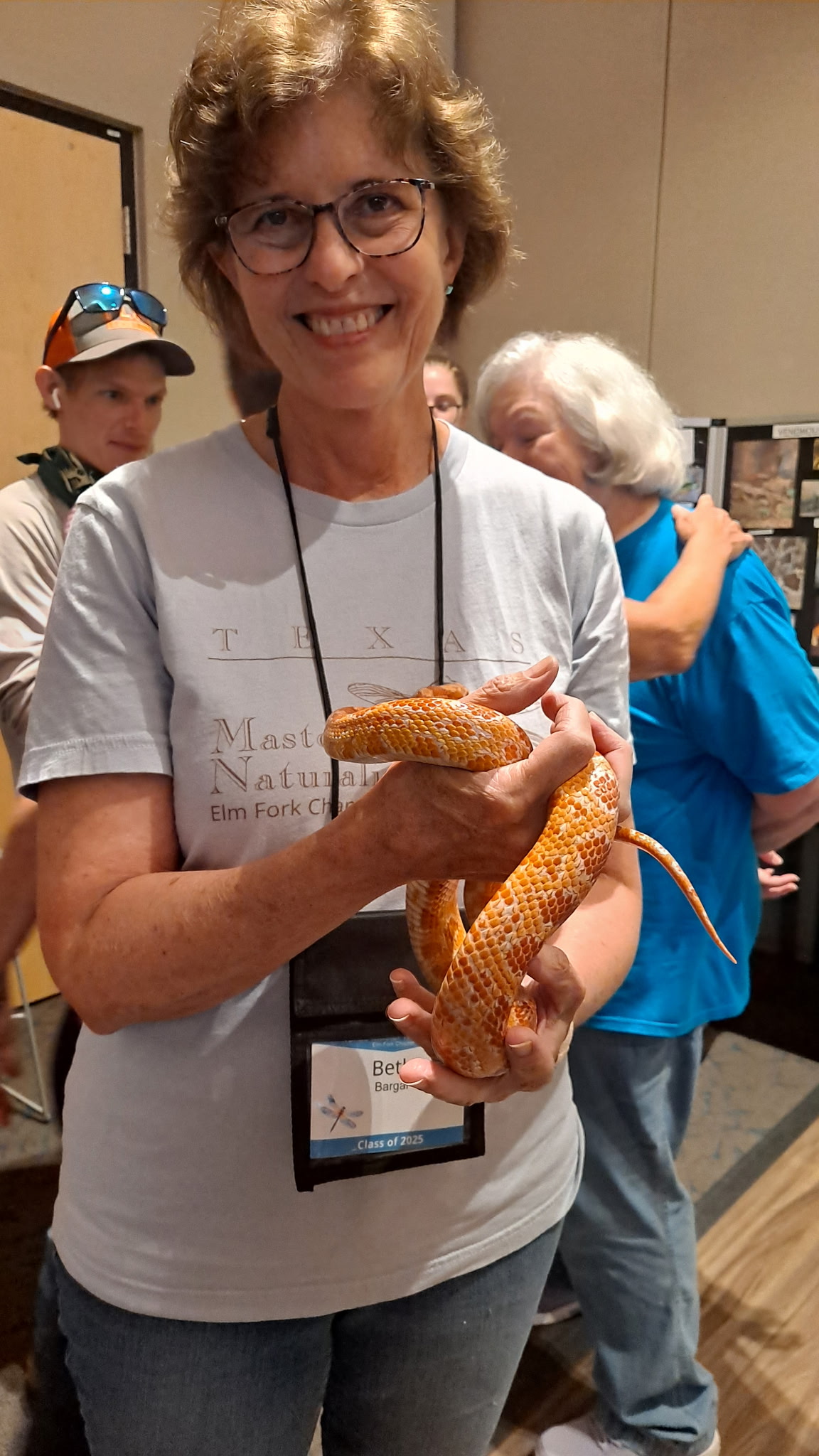A woman holds an orange snake