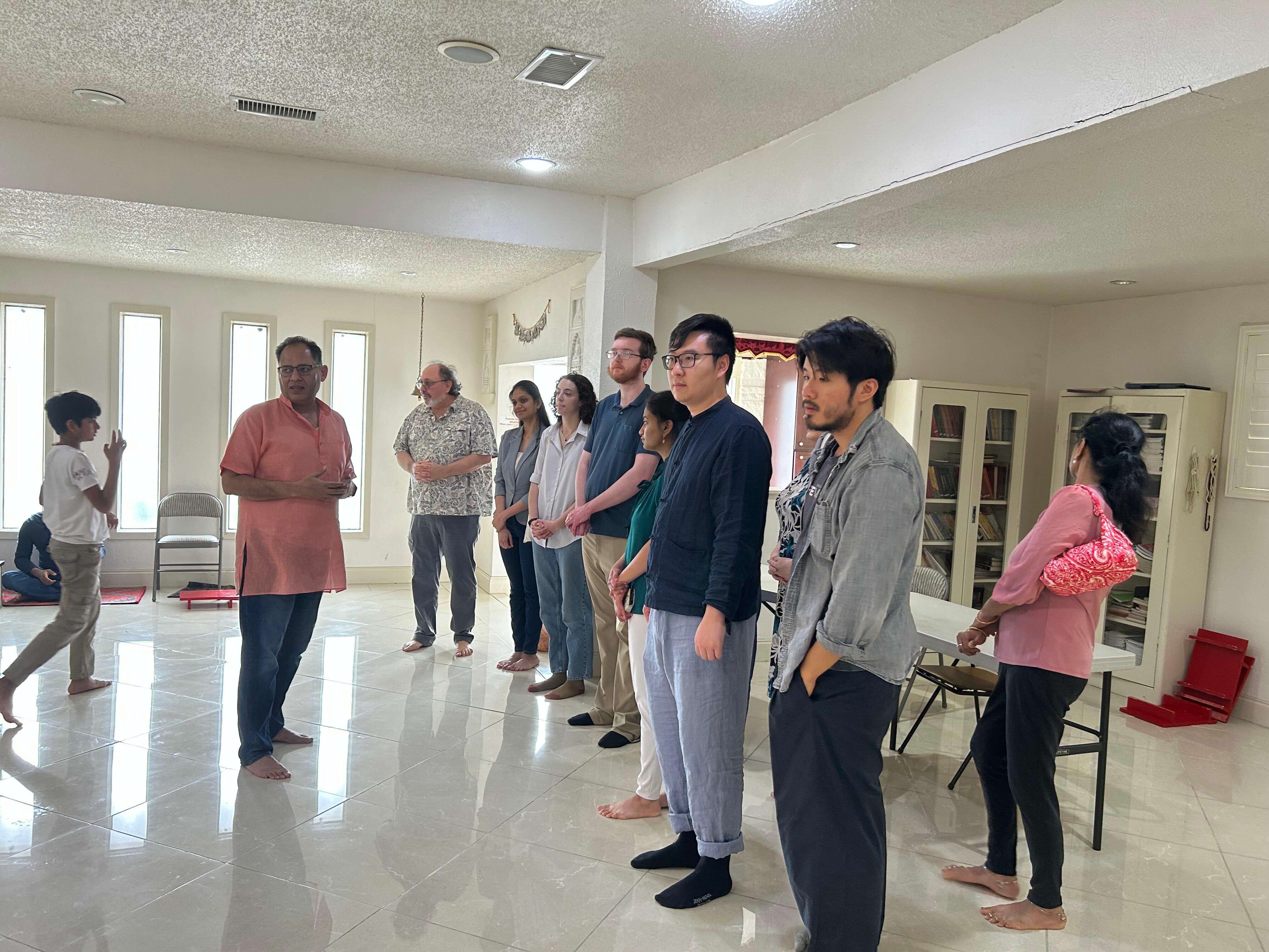 People stand in a row in a white room.