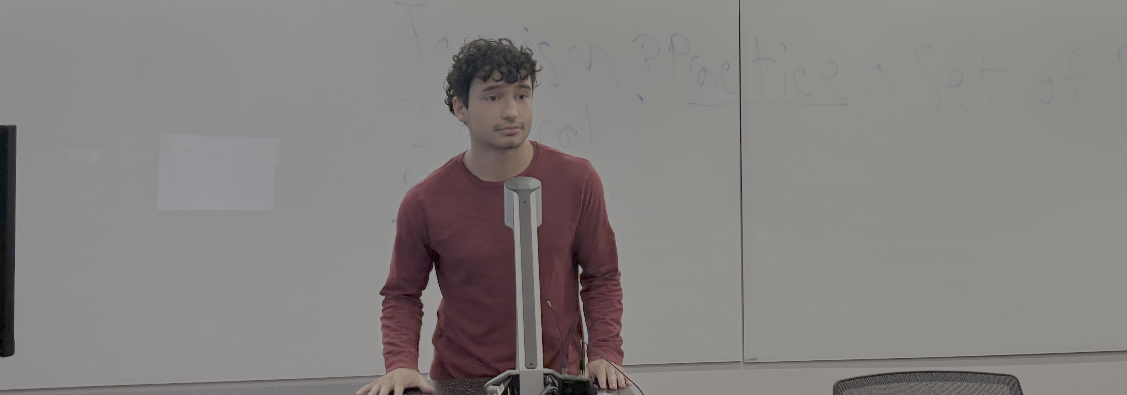 A person standing in front of a white board