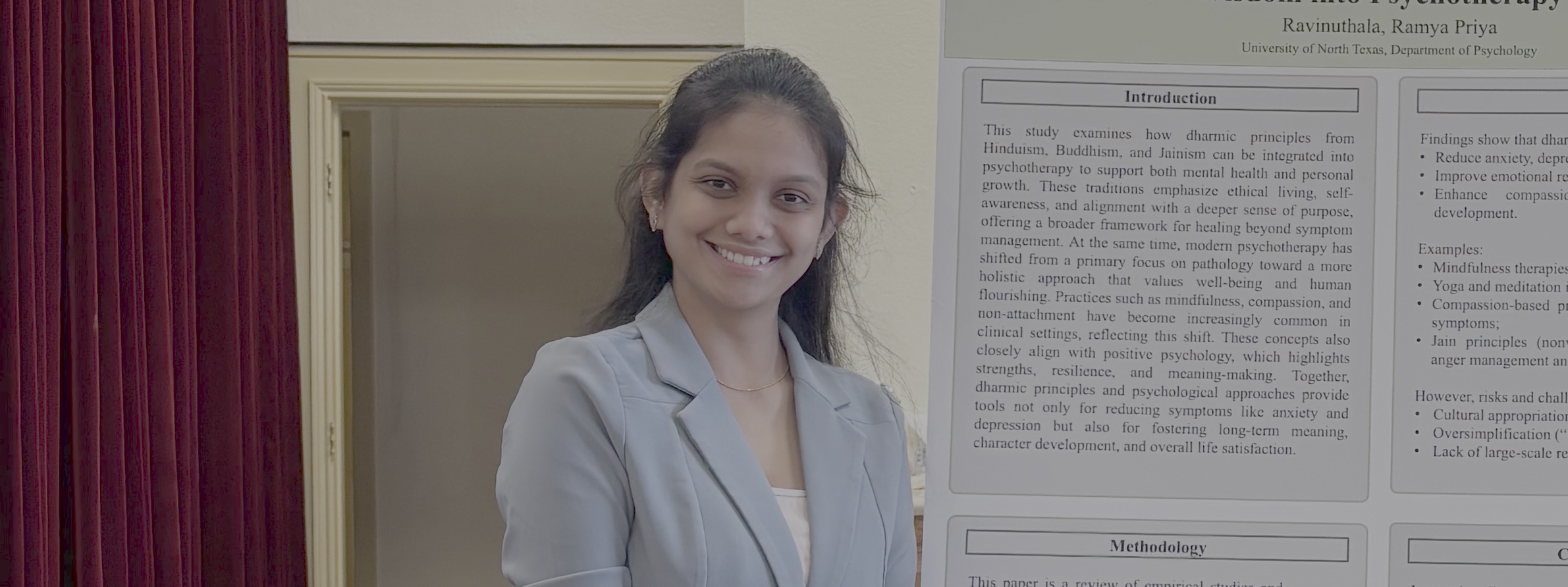 Person smiling and standing in front of a poster.