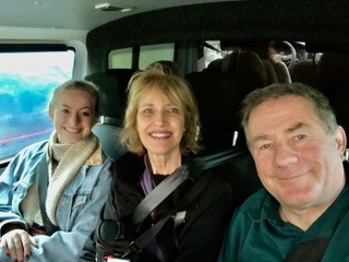 Three people in the front seat of a helicopter.