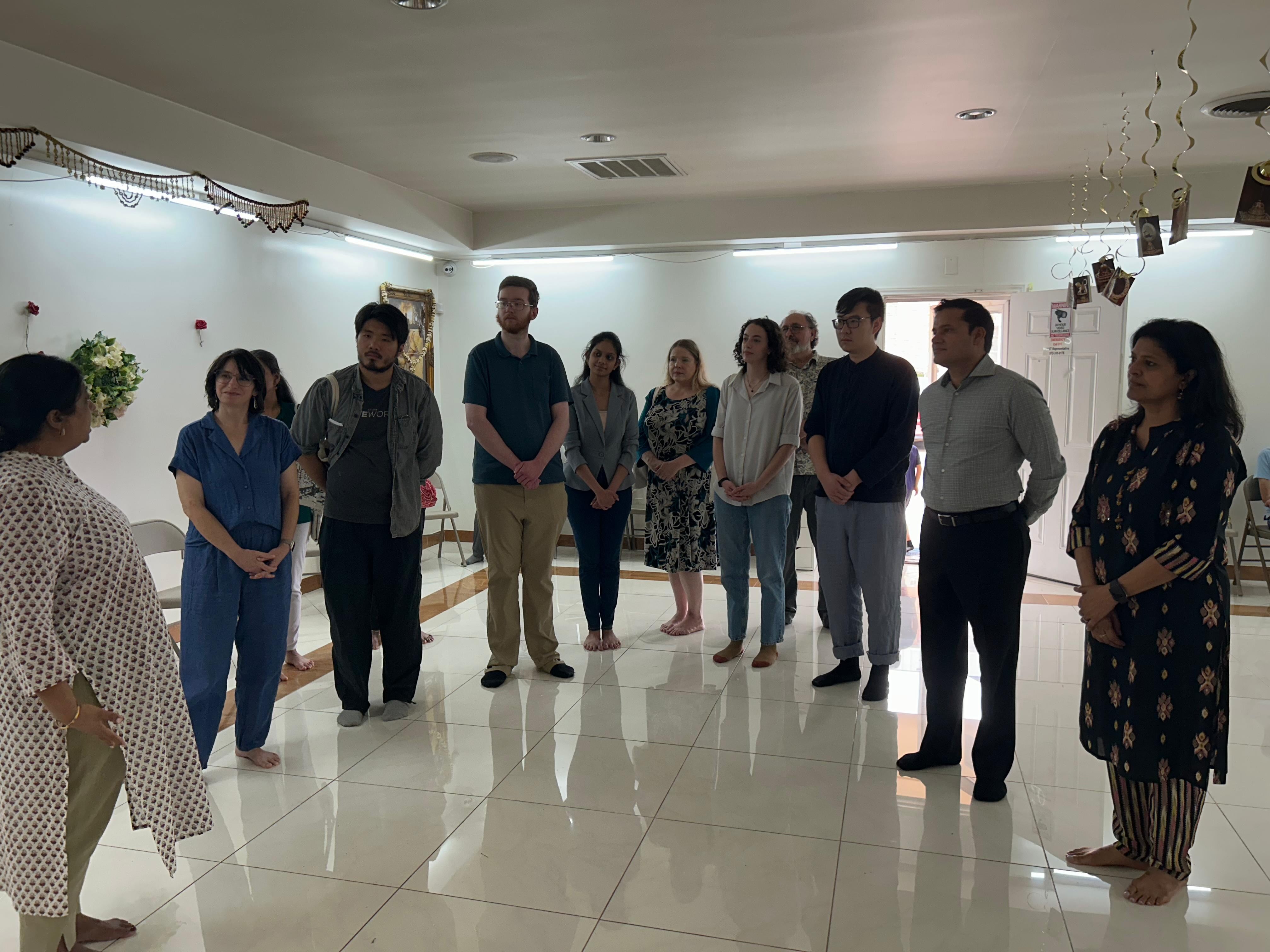 People stand in a semicircle in a white room.