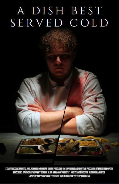 Chef in low light with tray of food in front of him.