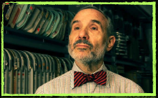 Portrait of Kaufman wearing a red bow tie looking up and to the left. He has a salt and pepper beard.  