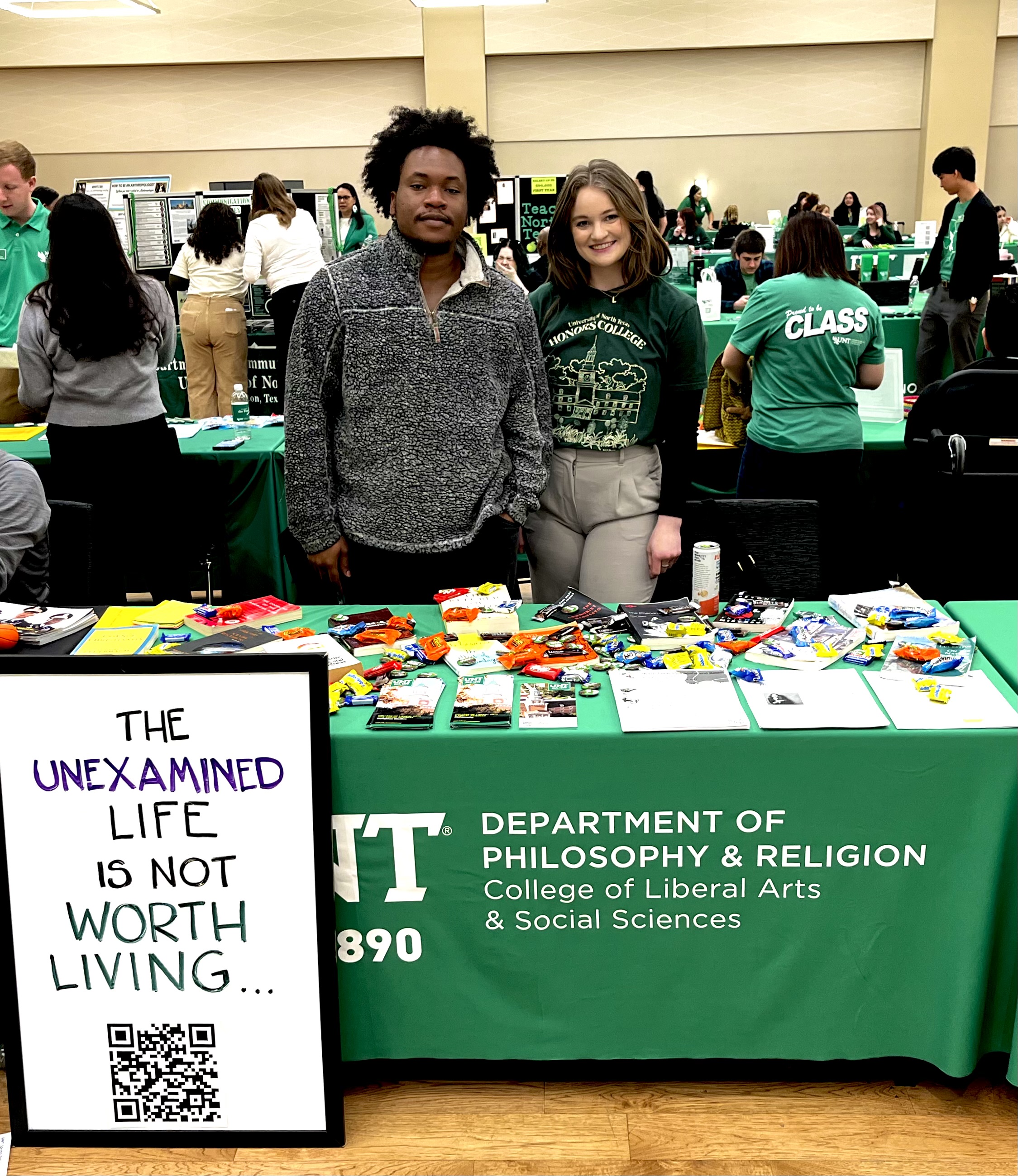 Philosophy students standing together new the philosophy table during preview day 