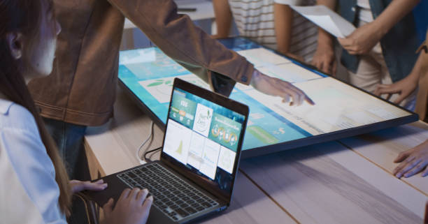 Students working with professor on laptop