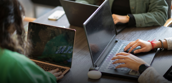 Students around table with laptops
